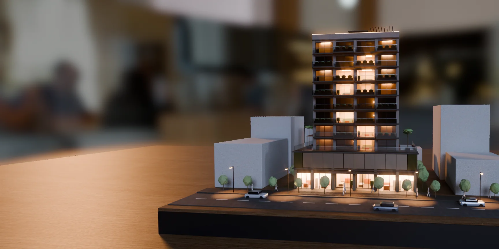 Maquete do edifício pronto sobre a mesa ao entardecer, com as janelas acesas